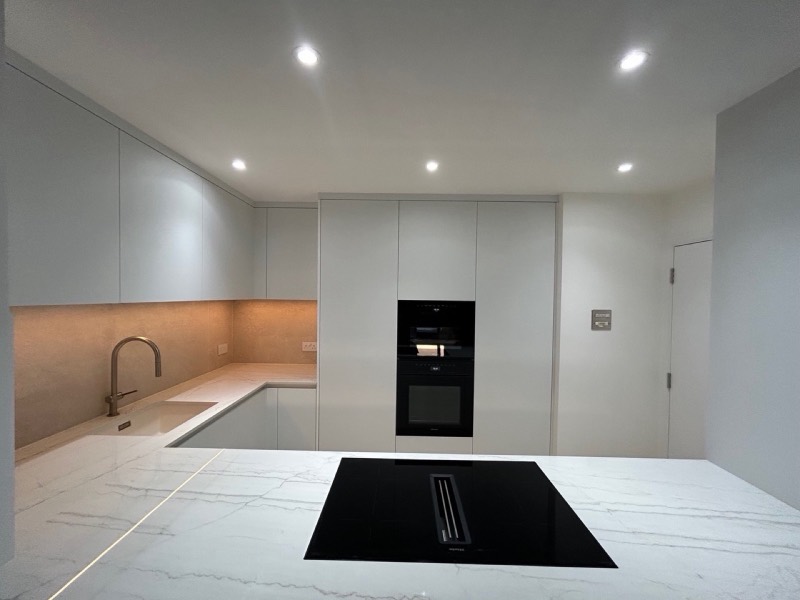 A newly finished room mid-renovation, with a marble-effect island and integrated ovens.